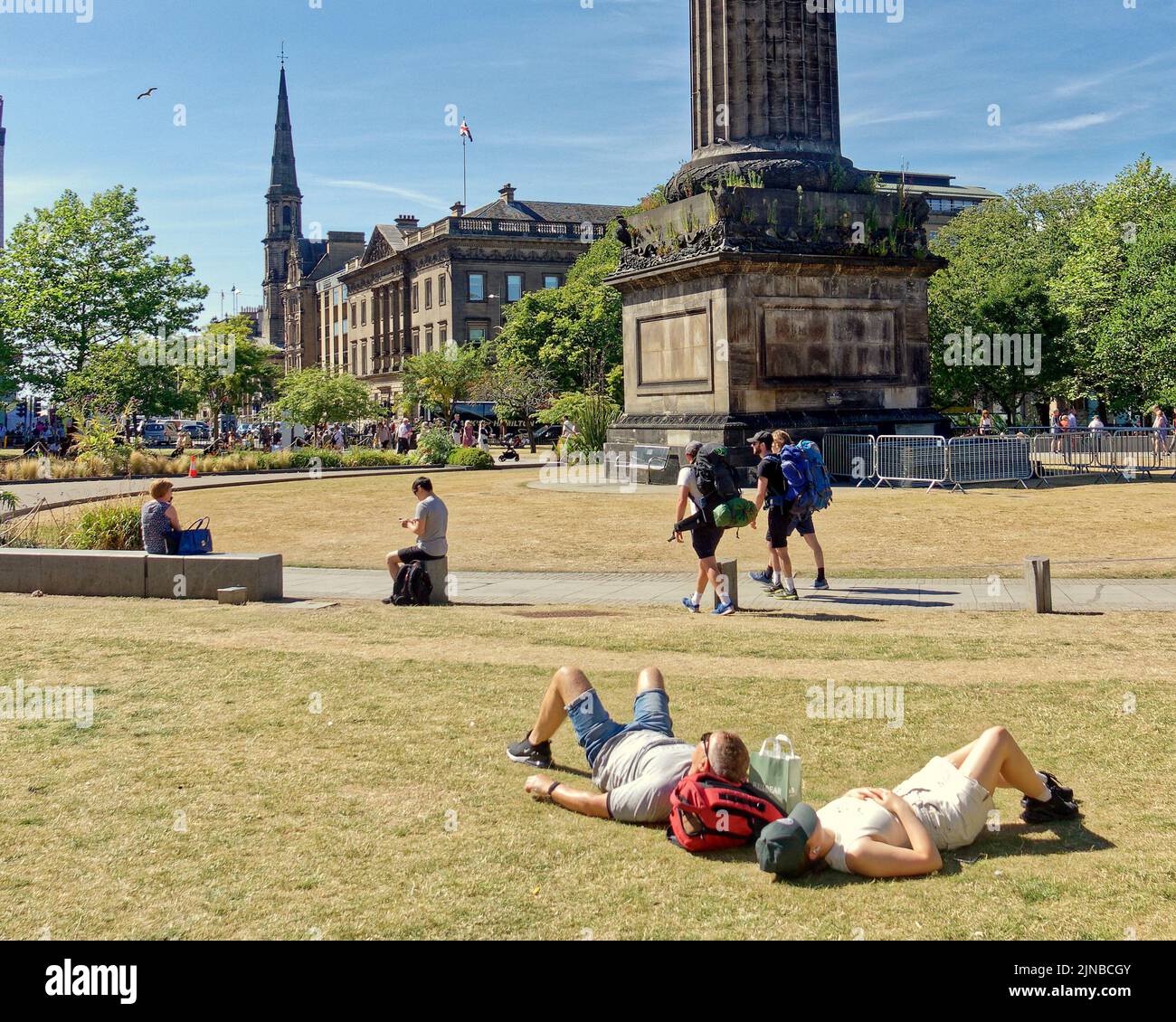 Edinburgh, Scotland, UK  10th August,  2022. UK Weather: St Andrews Square, Sunny weather on the way saw locals and tourists toast in the sun as the grass on princes street gardens burned and  they took in the acts and flyer chuckers on the royal mile and mound. Credit Gerard Ferry/Alamy Live News Stock Photo