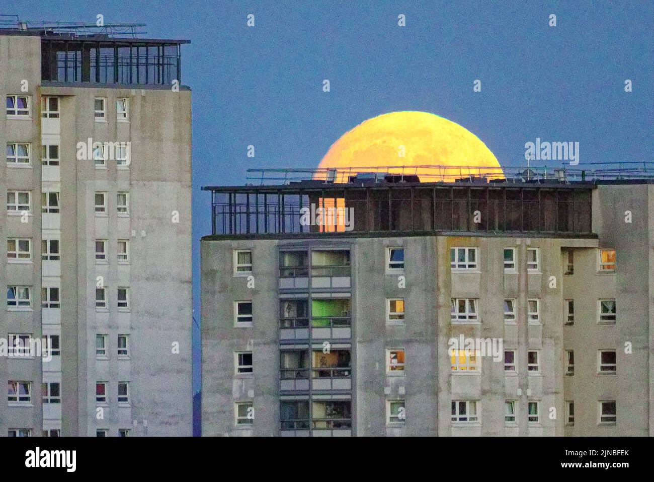 Glasgow, Scotland, UK  10th August,  2022. UK Weather: Sunny weather saw a nearly full Sturgeon moon yje last super moon of the year soar over the council towers of knightswood with the castlemilk estate in the far distance. Credit Gerard Ferry/Alamy Live News Stock Photo
