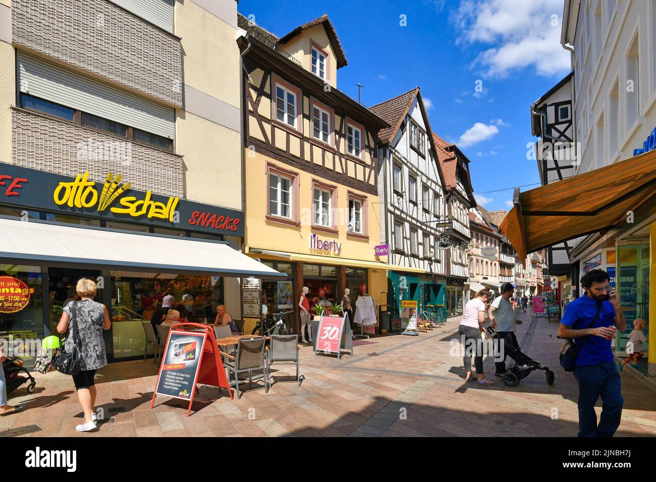 Neustadt an der Weinstrasse, Germany - August 2022: Old historic city center with small shops, sidewalk cafes and people on sunny day Stock Photo