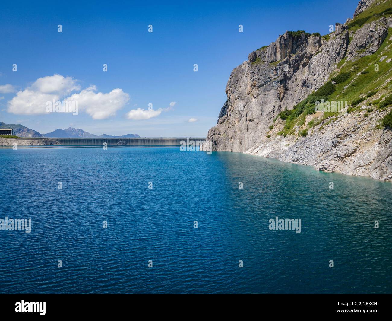 Aerial shot of the Luenersee with dam wall and rocks in Vorarlberg, Austria Stock Photo