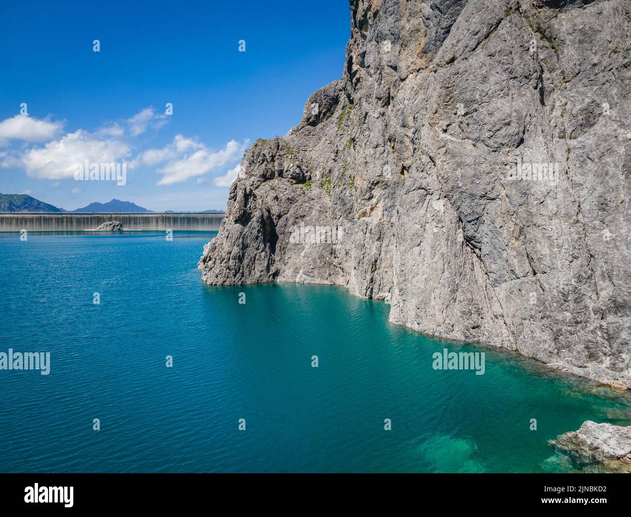 Aerial shot of the Luenersee with dam wall and rocks in Vorarlberg, Austria Stock Photo
