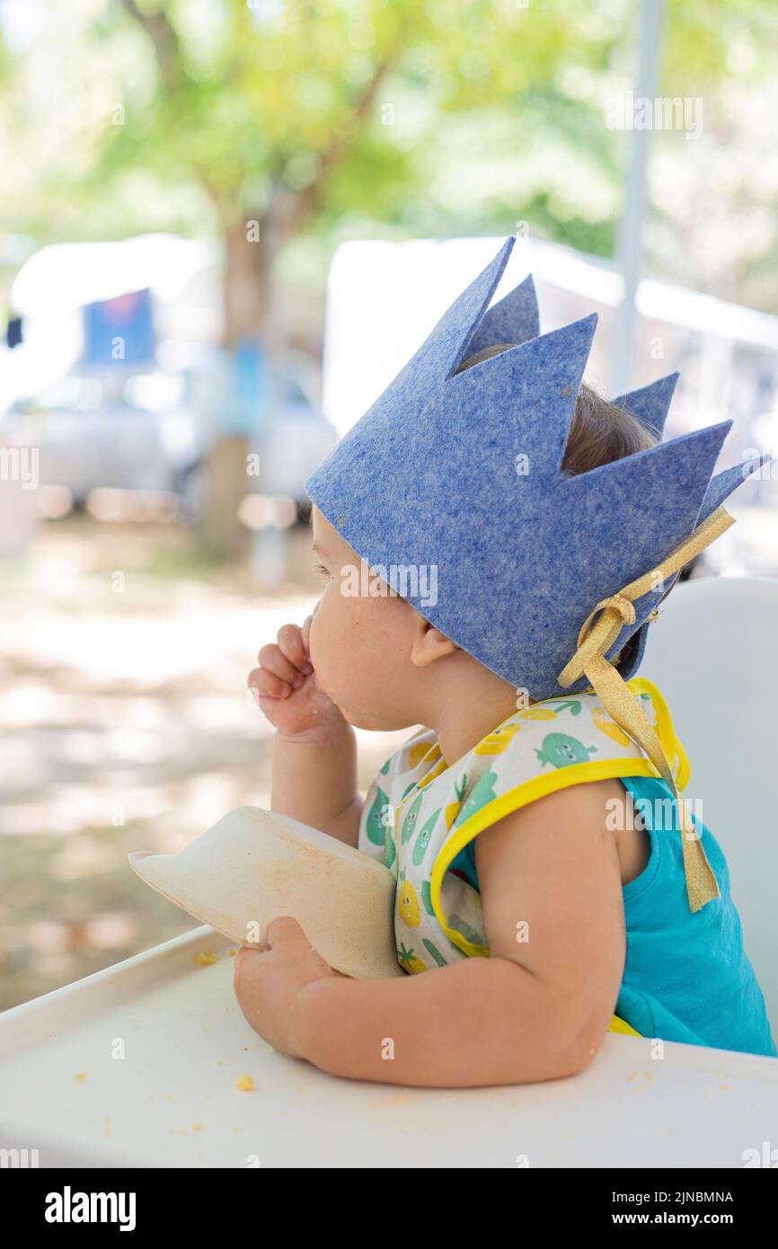 baby boy celebrating first birthday with felt crown during summer vacations, outdoor. Profile portrait, outdoor. Stock Photo