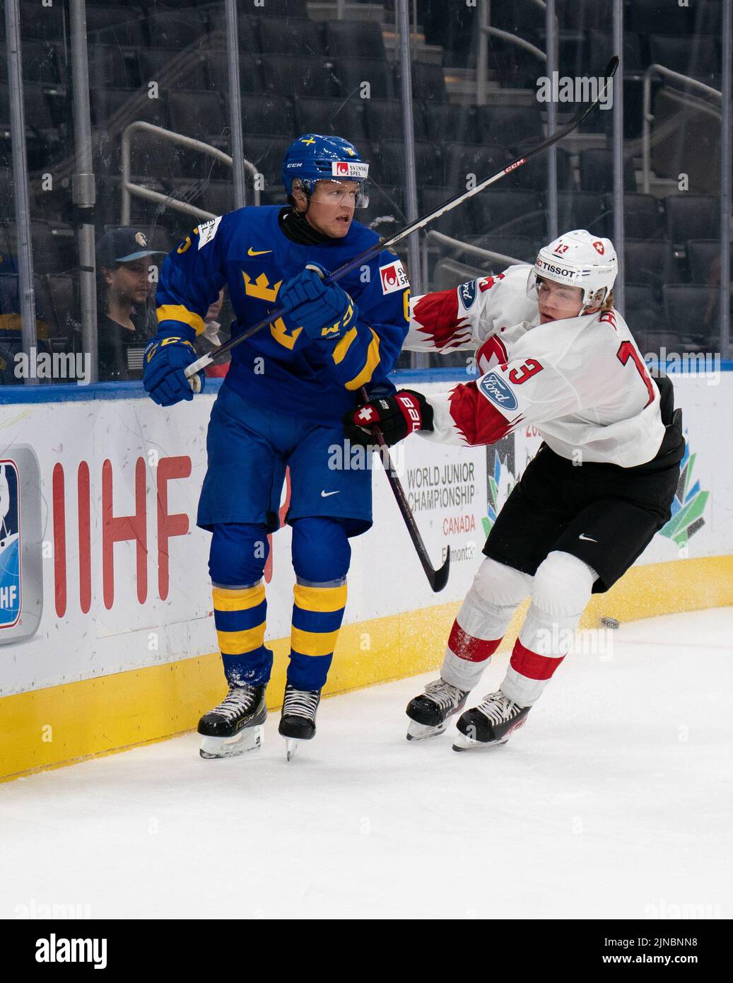 Edmonton, Alberta, Canada. 10th Aug, 2022. MATS ALGE (13) of Switzerland checks MANS FORSFJALL (6) of Sweden during the first period of a World Junior Championship game at Rogers Place in Edmonton, Alberta. (Credit Image: © Matthew Helfrich/ZUMA Press Wire) Stock Photo