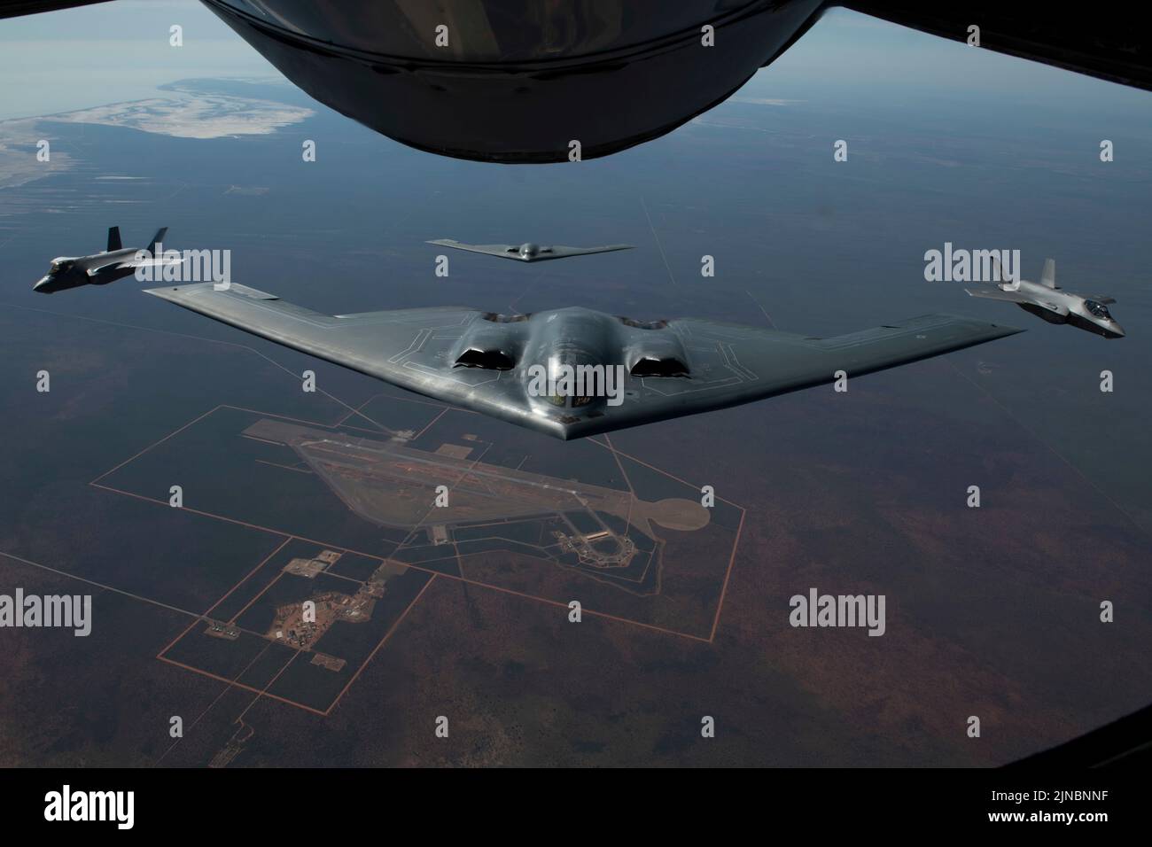 Amberley, Australia. 18 July, 2022. U.S. Air Force B-2 Spirit stealth strategic bombers, with the 509th Bomb Wing, approaches a KC-135 tanker to refuel escorted by Royal Australian Air Force fighter aircraft during exercise Koolendong 22, July 18, 2022 over Australia.  Credit: TSgt. Dylan Nuckolls/US Air Force/Alamy Live News Stock Photo