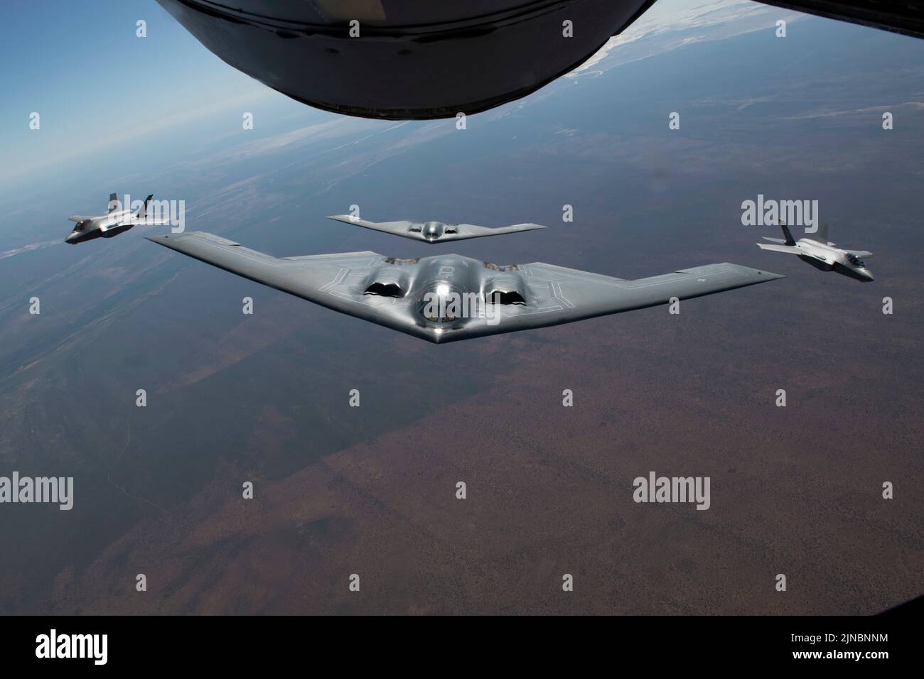 Amberley, Australia. 18 July, 2022. U.S. Air Force B-2 Spirit stealth strategic bombers, with the 509th Bomb Wing, approaches a KC-135 tanker to refuel escorted by Royal Australian Air Force fighter aircraft during exercise Koolendong 22, July 18, 2022 over Australia.  Credit: TSgt. Dylan Nuckolls/US Air Force/Alamy Live News Stock Photo