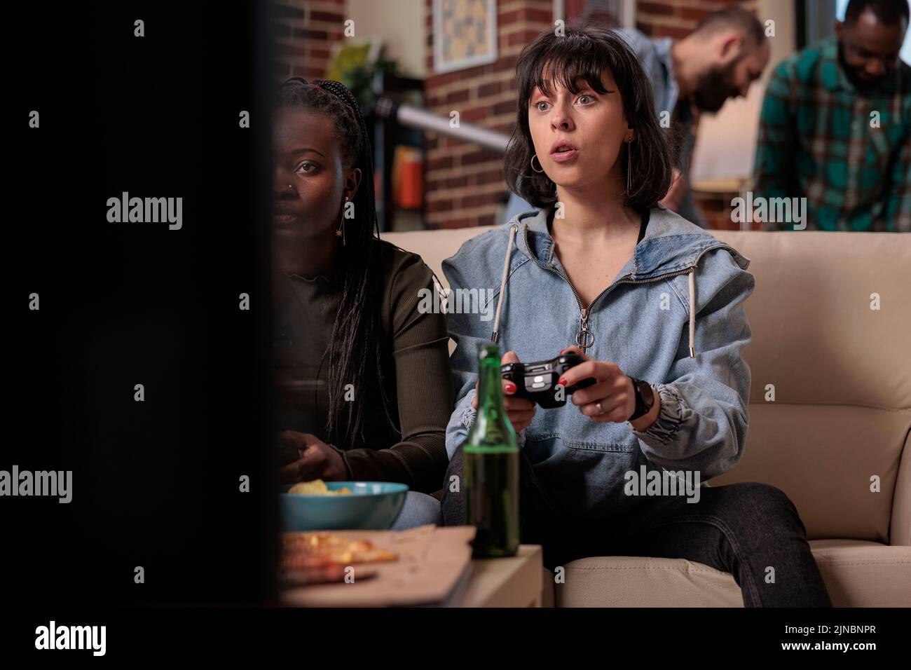 Multiethnic friends using tv console to play video games at home ...