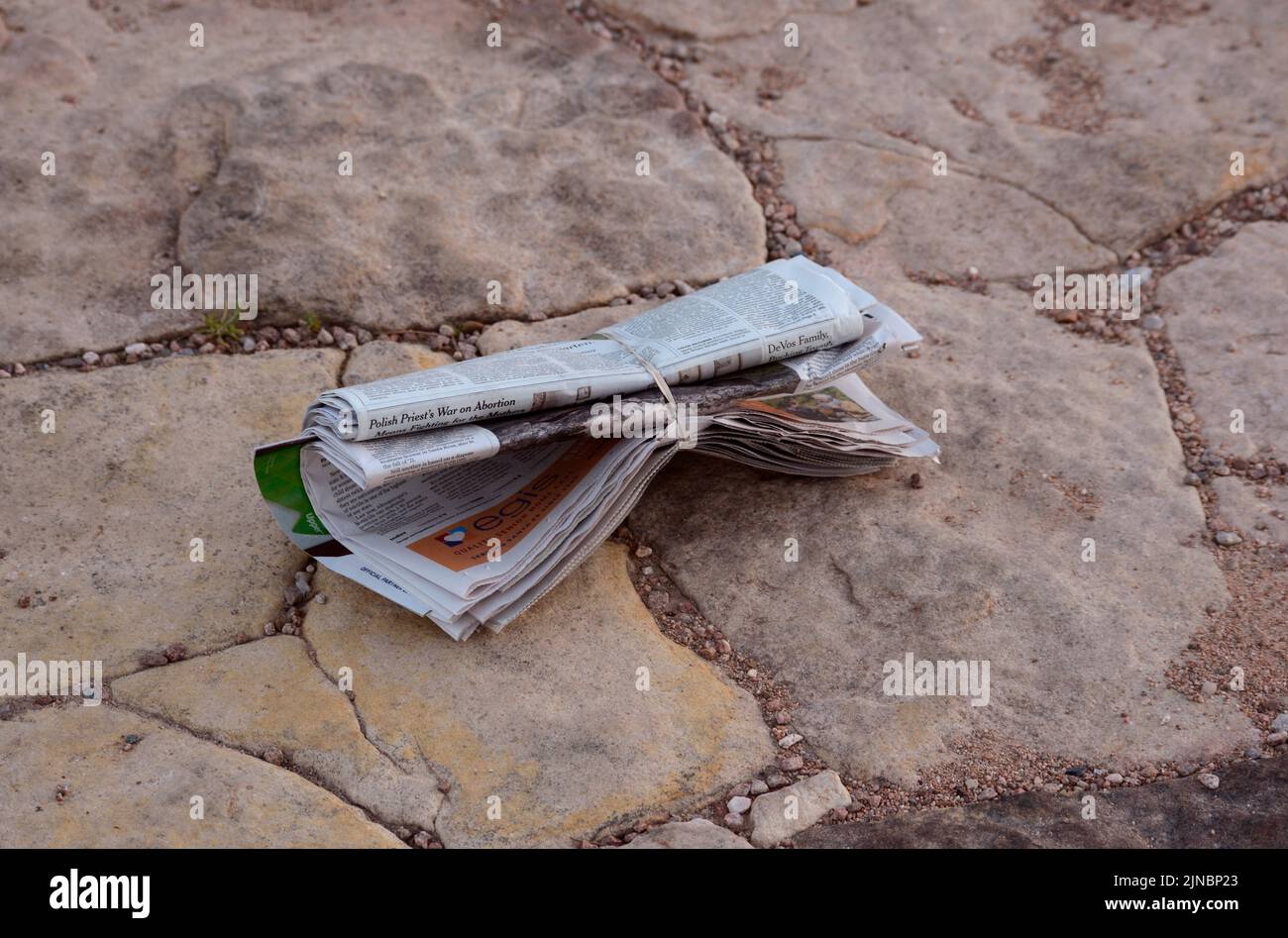 A daily newspaper deposited on a subscriber's driveway in Santa Fe, New Mexico Stock Photo