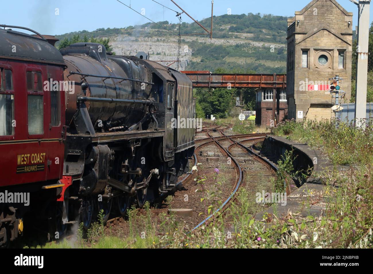 Stanier black five steam train preparing to leave Carnforth on 10th August 2022 for a test run to Hellifield, semaphore signal,old stone signal box. Stock Photo