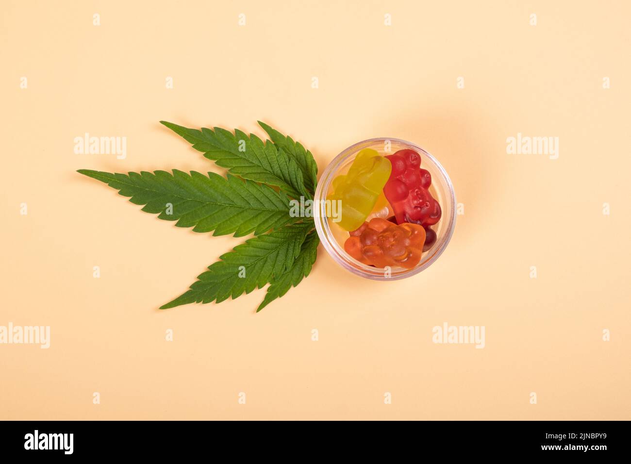 thc jelly candies, cannabis sweets drugs and green leaf on yellow