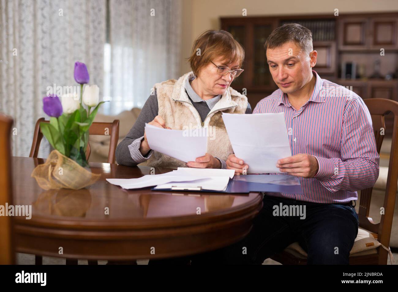Man with elderly mother discussing documents Stock Photo