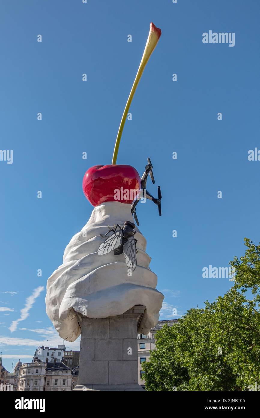 London, UK- July 4, 2022: Trafalgar Square. Whipped Cream With red Cherry on top statue, named The End, fly and drone, against blue sky. Some green fo Stock Photo