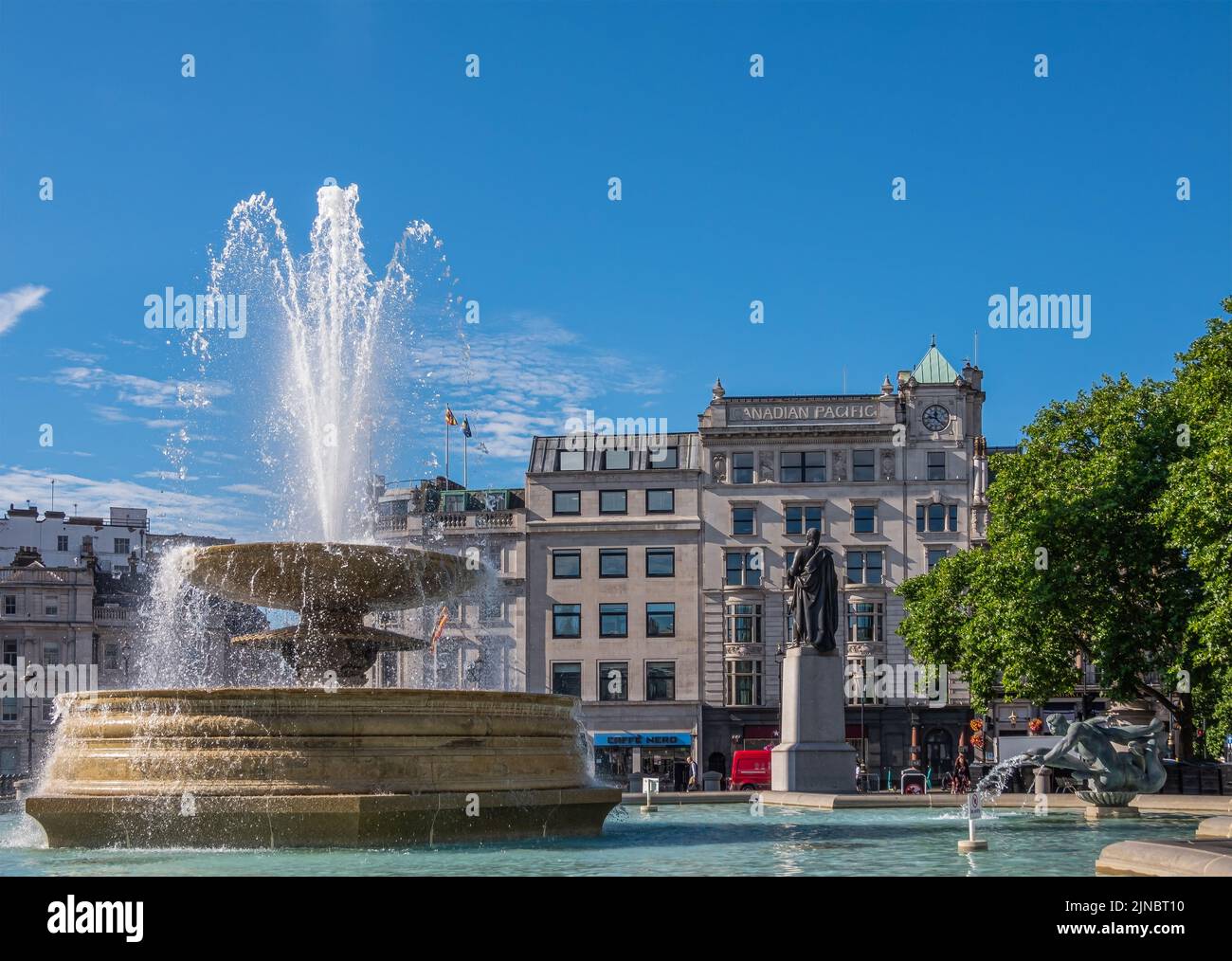 London, UK- July 4, 2022: Trafalgar Square. West side fountain with mermaid statue and Cockspur Street and Canadian Pacific building in back under blu Stock Photo