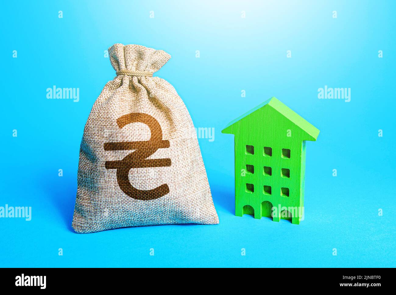 Ukrainian hryvnia money bag and green Resident building. Investments in sustainable housing. Investment in green technologies. Reduced emissions, ener Stock Photo