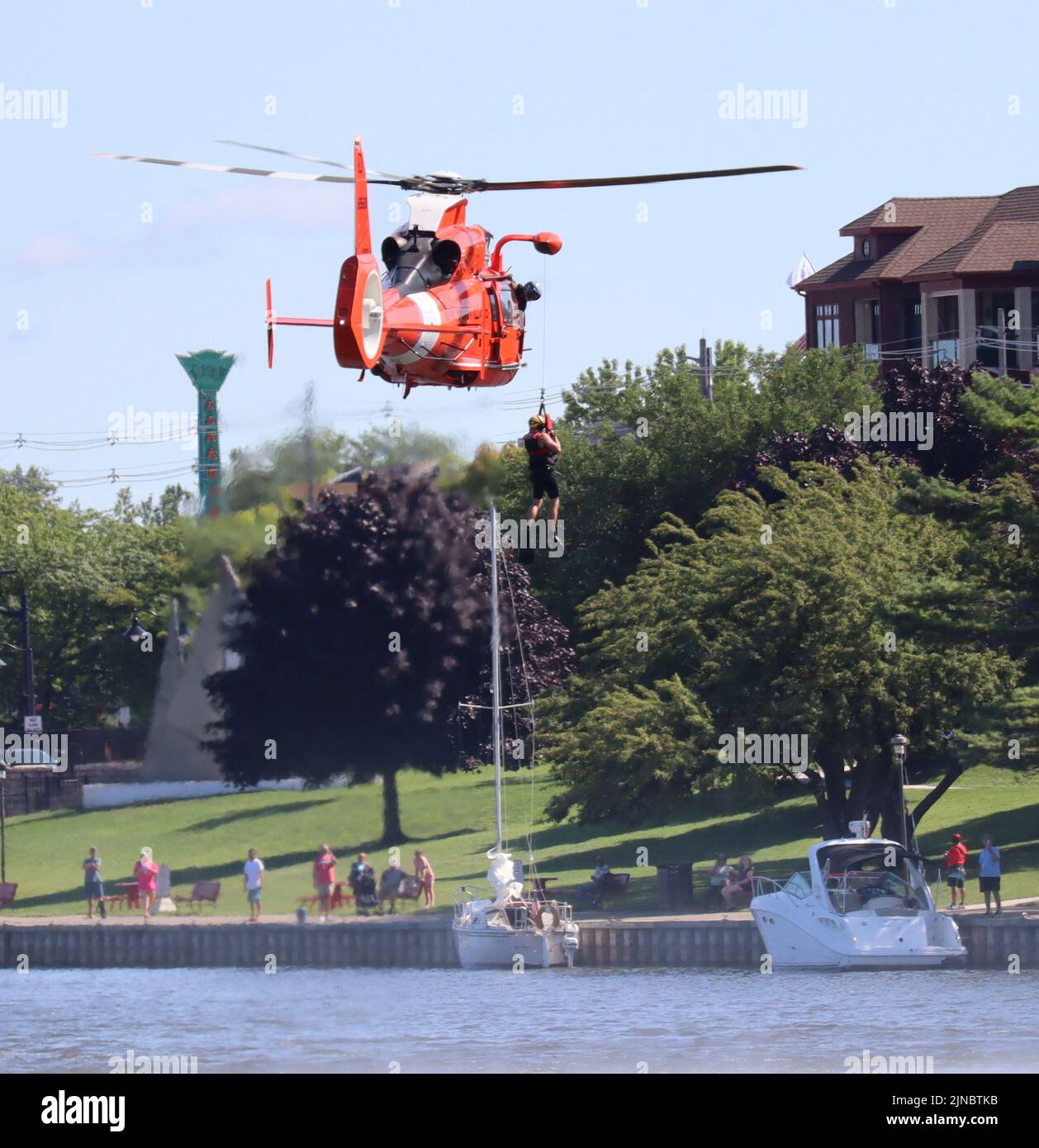 A rescue swimmer is lowered from an MH65D Dolphin during a searchand