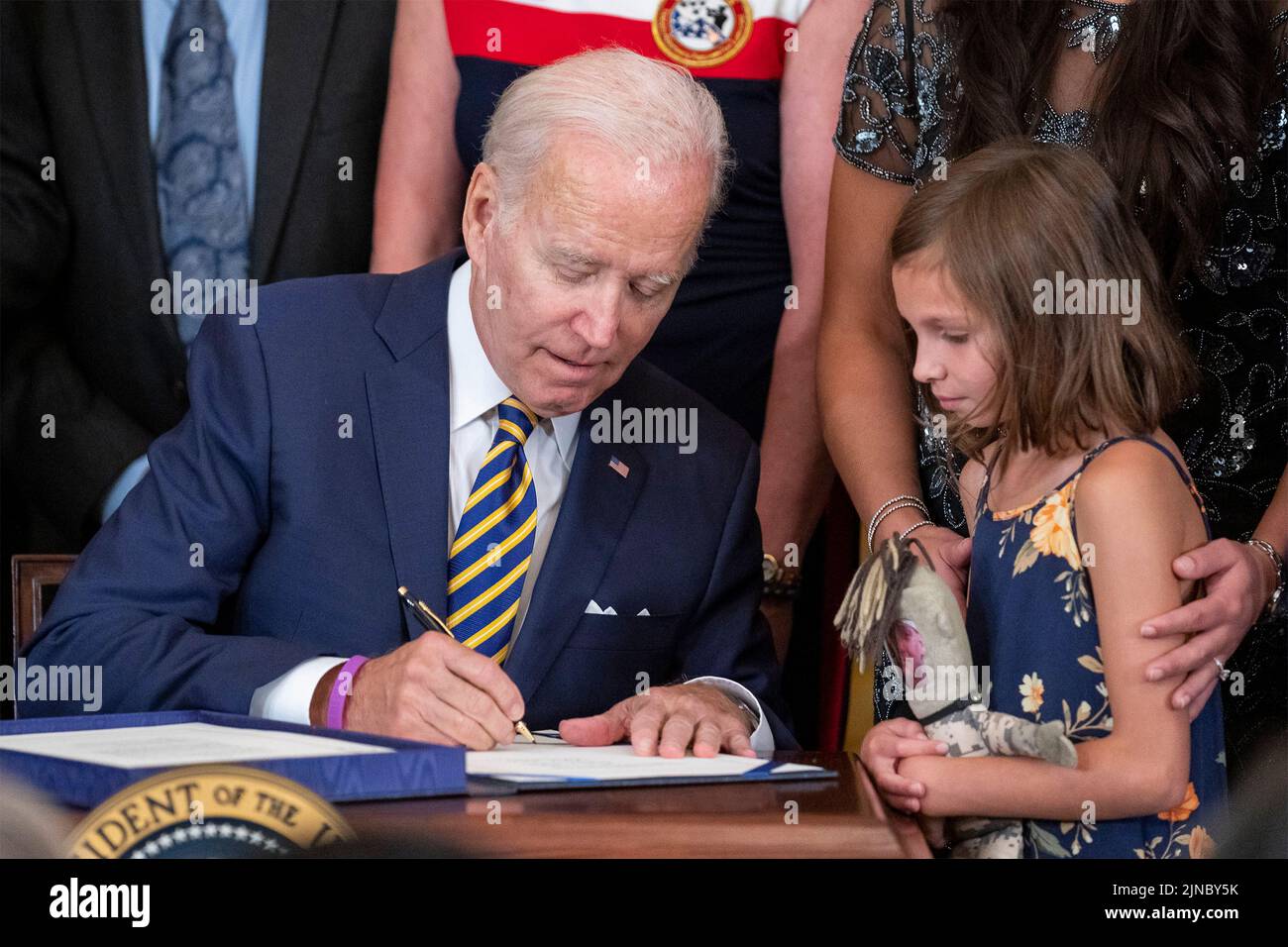 Washington, United States Of America. 10th Aug, 2022. Washington, United States of America. 10 August, 2022. U.S President Joe Biden, signs the PACT Act of 2022 into law as Brielle Robinson, daughter of Sgt. 1st Class Heath Robinson, watches in the East Room of the White House, August 10, 2022 in Washington, DC The new law expands health care benefits for veterans who developed illnesses because of their exposure to toxic substances during their service. Credit: Adam Schultz/White House Photo/Alamy Live News Stock Photo
