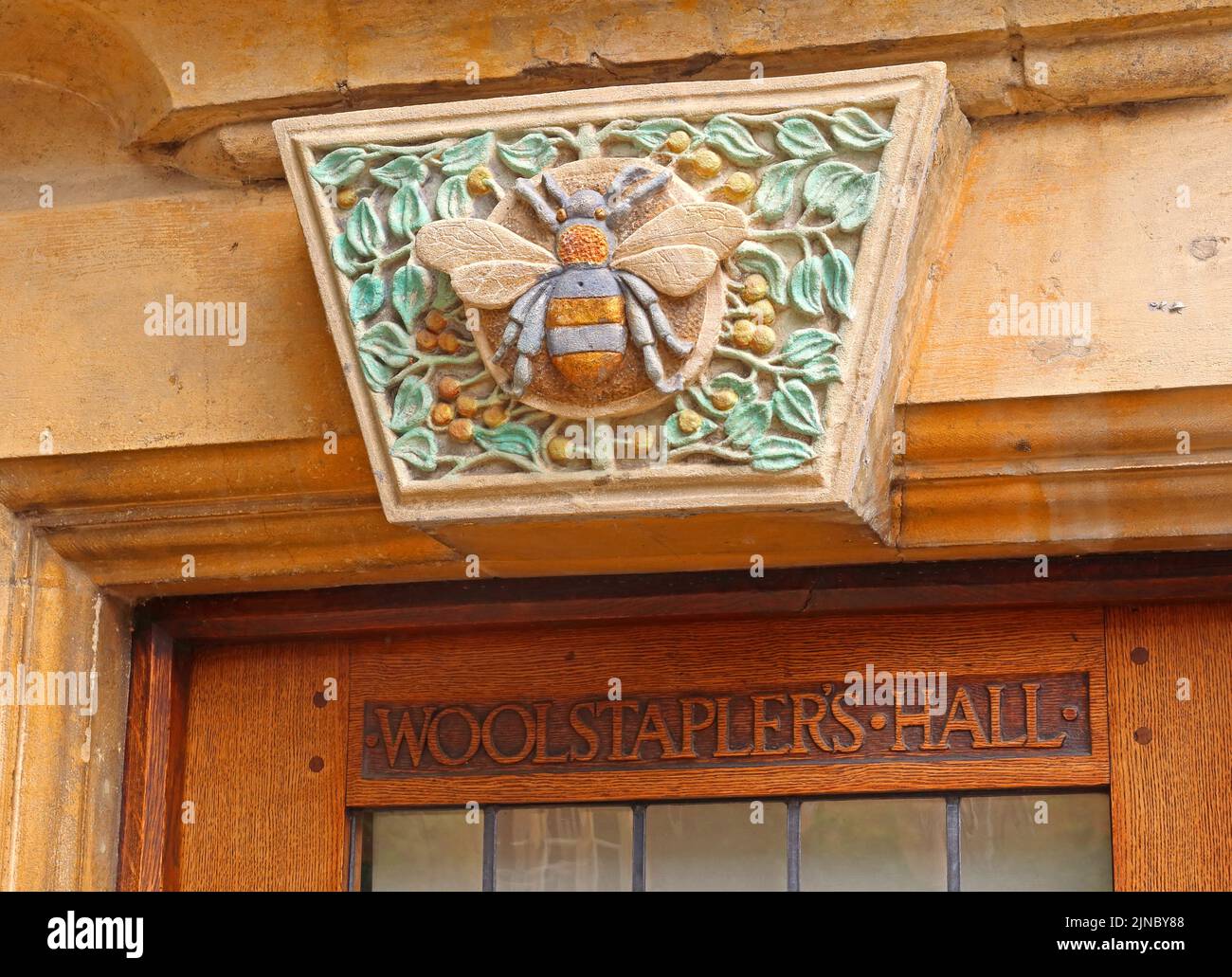 Historic woolstaplers hall, carved wood entrance,worker bee, Chipping Camden, Cotswolds market town, Cotswold, Oxfordshire, England, UK, GL55 6AA Stock Photo