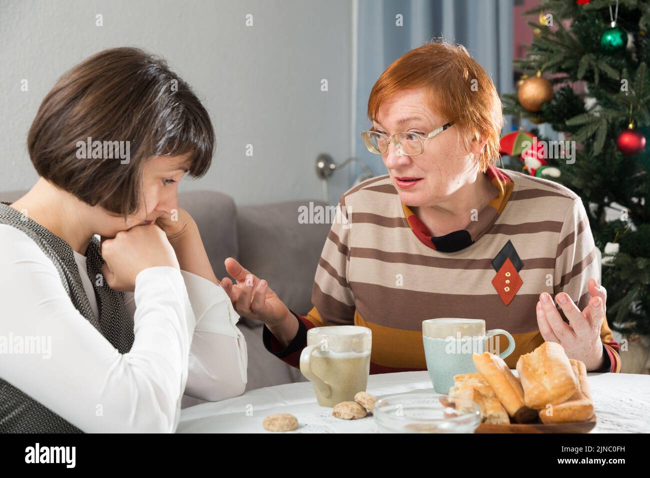 Senior woman calming chagrined female Stock Photo - Alamy