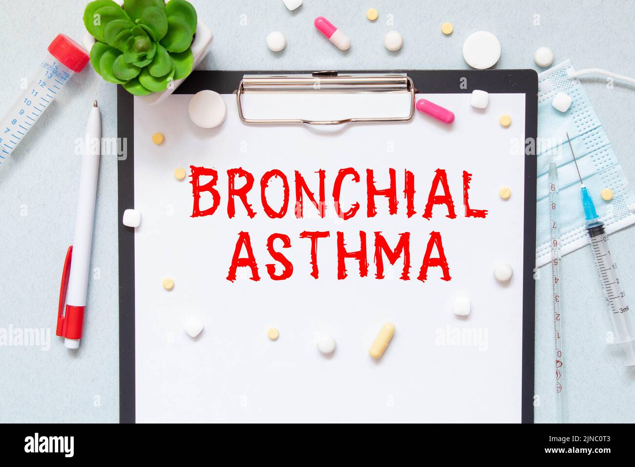 On a purple background a stethoscope with yellow list with text BRONCHIAL ASTHMA. Stock Photo