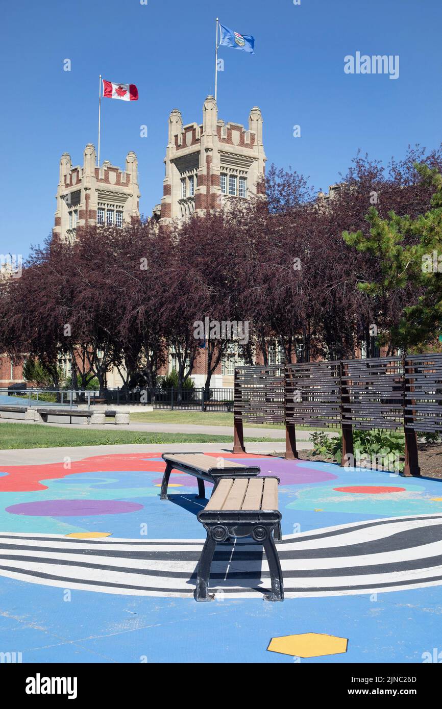 Benches at SAIT (Southern Alberta Institute of Technology) campus with Canadian and Albertan flags flying over Heritage Hall in Calgary, Canada Stock Photo