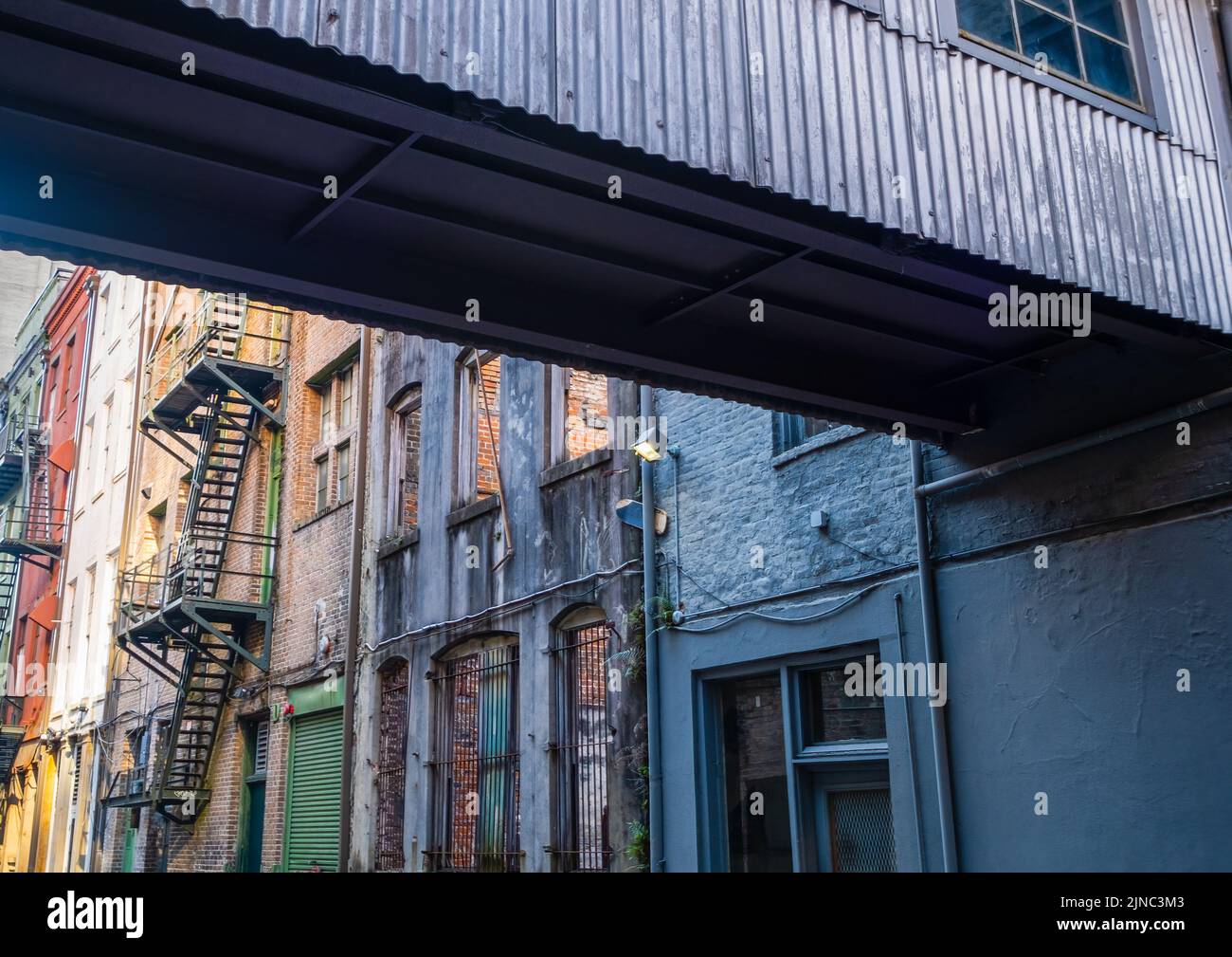 NEW ORLEANS, LA, USA - FEBRUARY 2, 2020: Alley with fire escapes and crossover walkway in downtown New Orleans Stock Photo