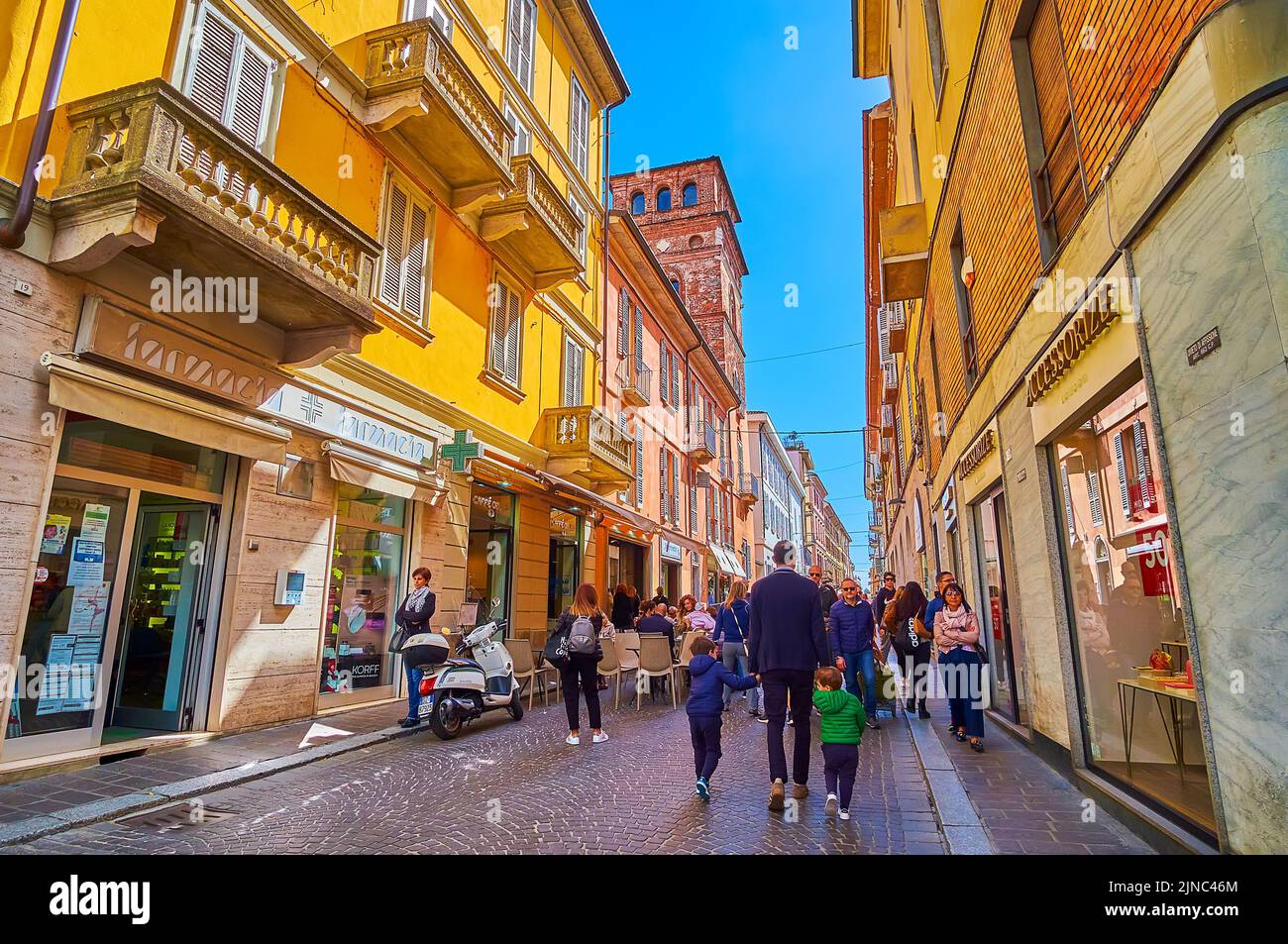 PAVIA, ITALY - APRIL 9, 2022: Walk along crowded pedestrian street in the heart of old city, on April 9 in Pavia, Italy Stock Photo