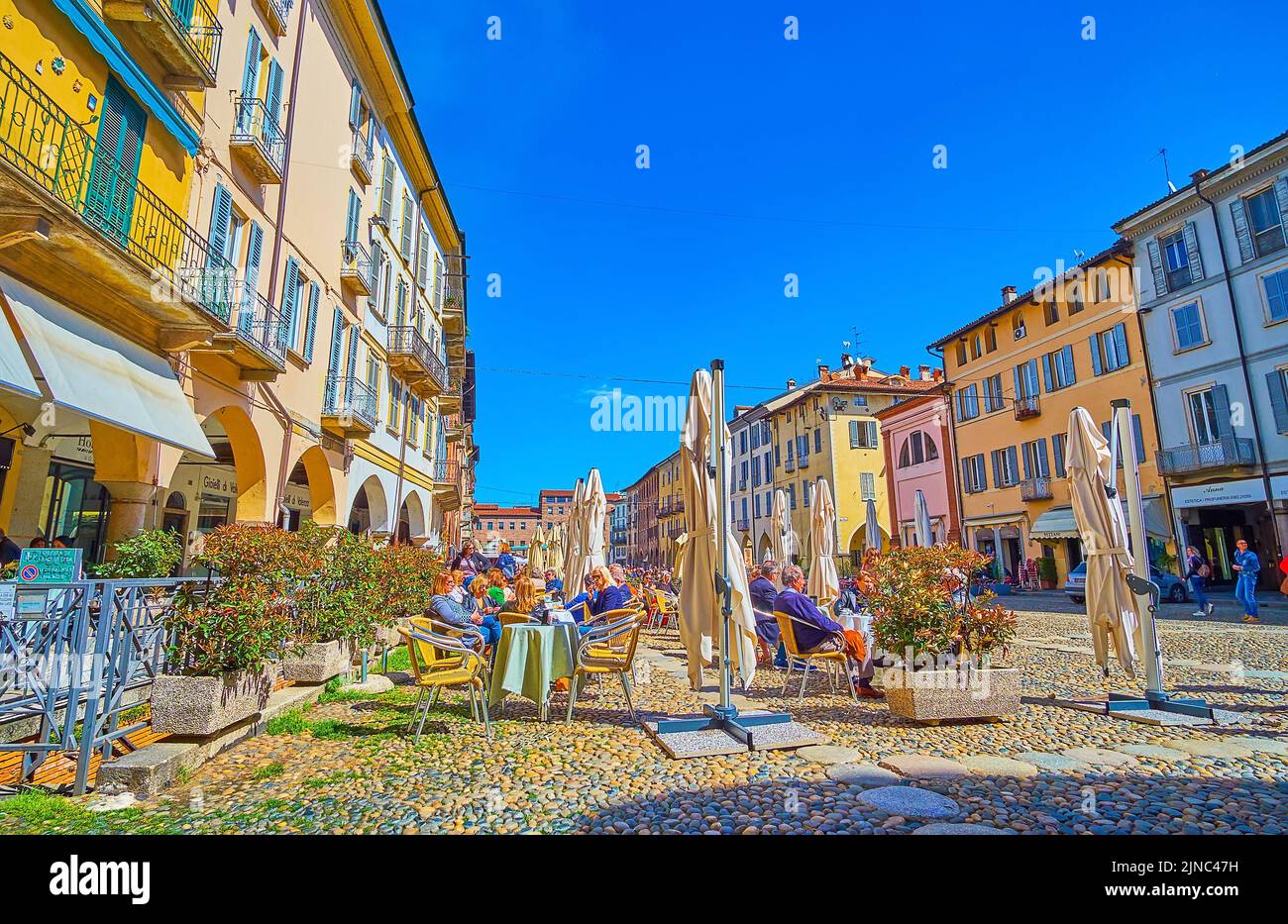 PAVIA, ITALY - APRIL 9, 2022: Outdoor tabbles of the restaurants on Piazza della Vittoria, on April 9 in Pavia, Italy Stock Photo