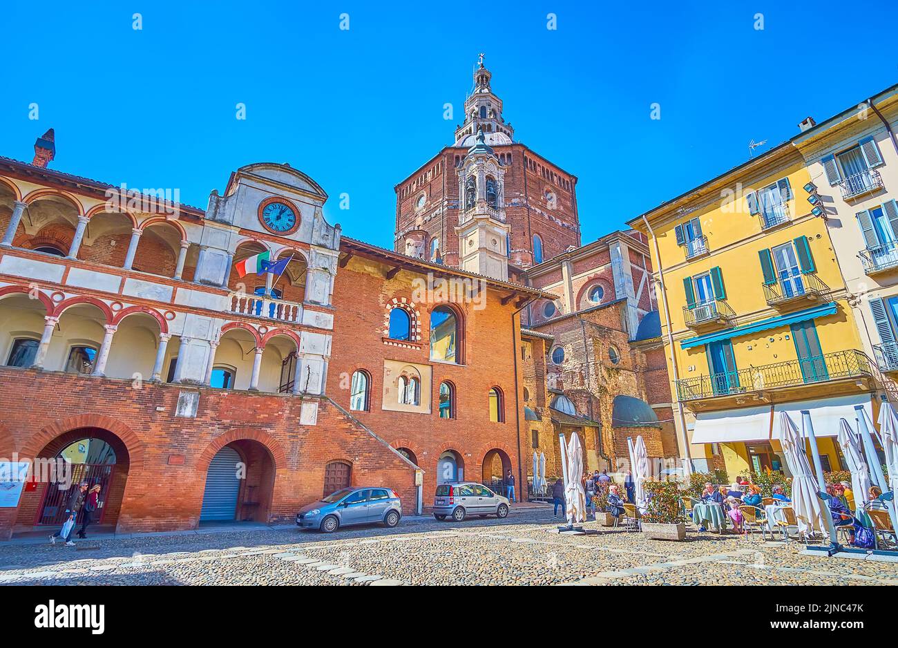 PAVIA, ITALY - APRIL 9, 2022: Beautiful medieval Palazzo Broletto and the dome of Cathedral, on April 9 in Pavia, Italy Stock Photo