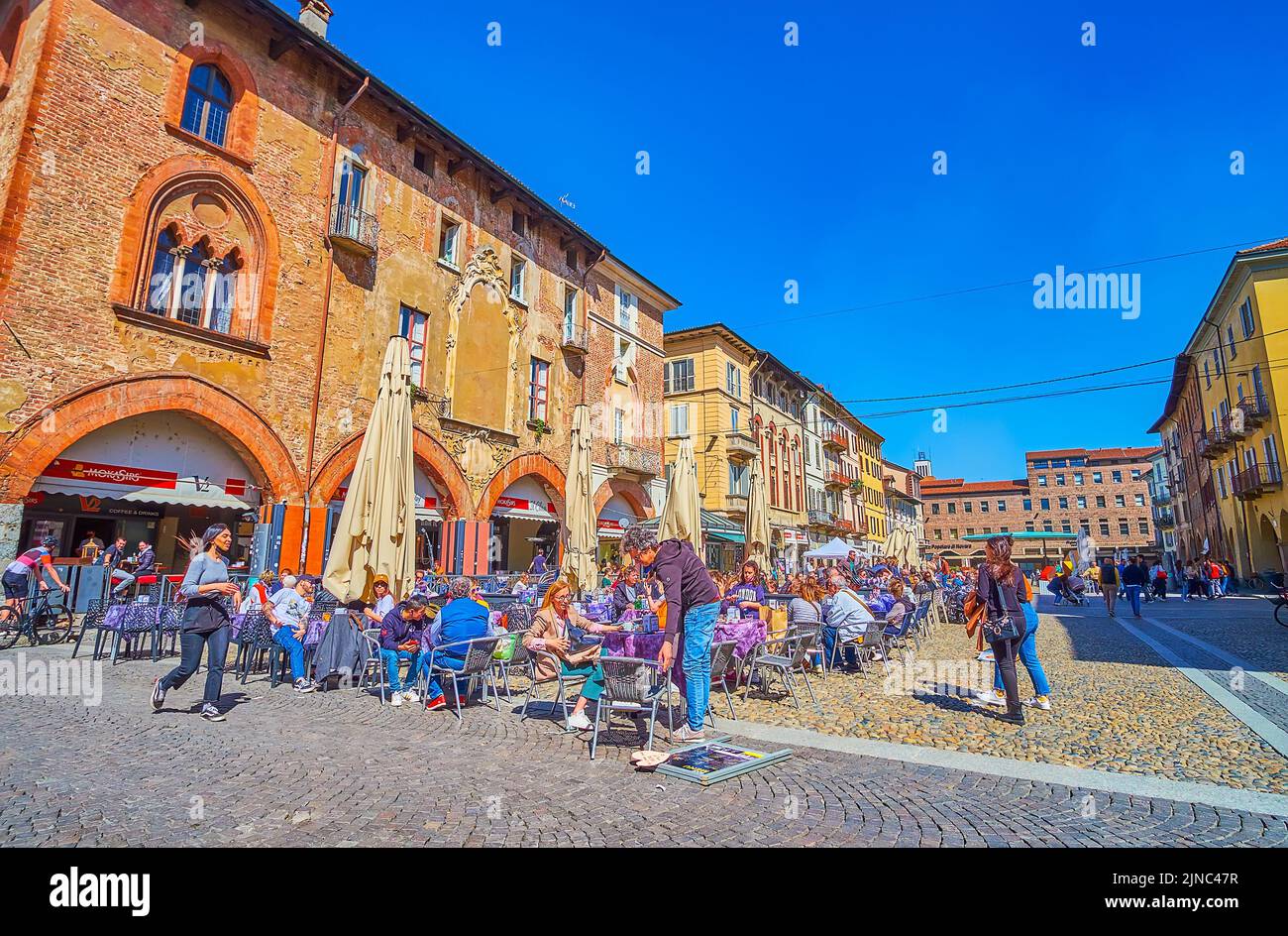 PAVIA, ITALY - APRIL 9, 2022: Relax in one of outdoor restaurants on Piazza della Vittorio, the main tourist hub of the city, on April 9 in Pavia, Ita Stock Photo