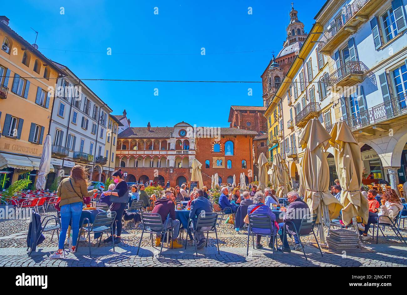 PAVIA, ITALY - APRIL 9, 2022: Piazza della Vittorio is one of the best places to rest in outdoor restaurant with a view on medival landmarks, on April Stock Photo