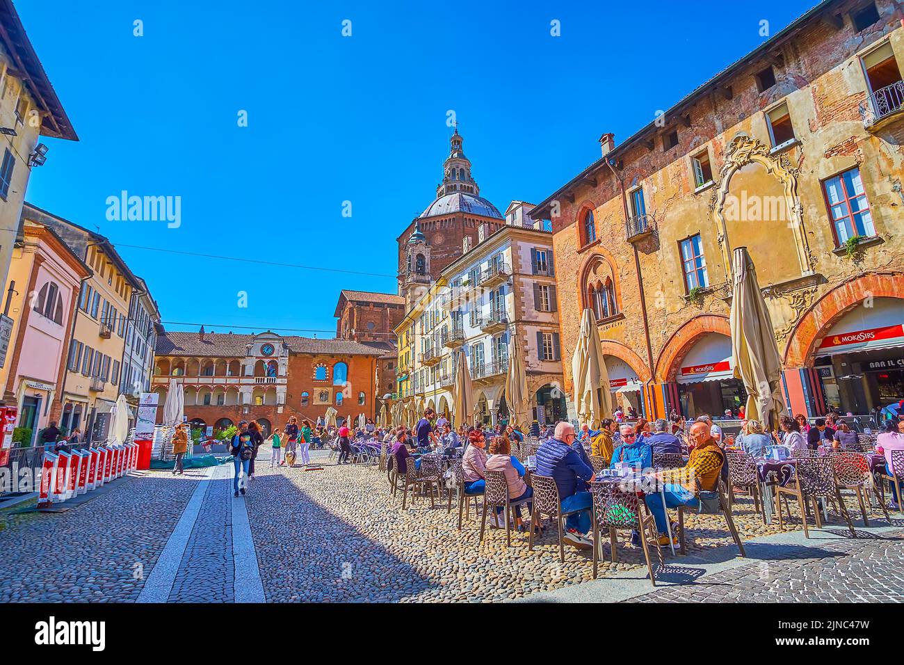 PAVIA, ITALY - APRIL 9, 2022: Restaurants on Piazaa della Vittorio with the great view on surrounding medieval palaces and villas, on April 9 in Pavia Stock Photo