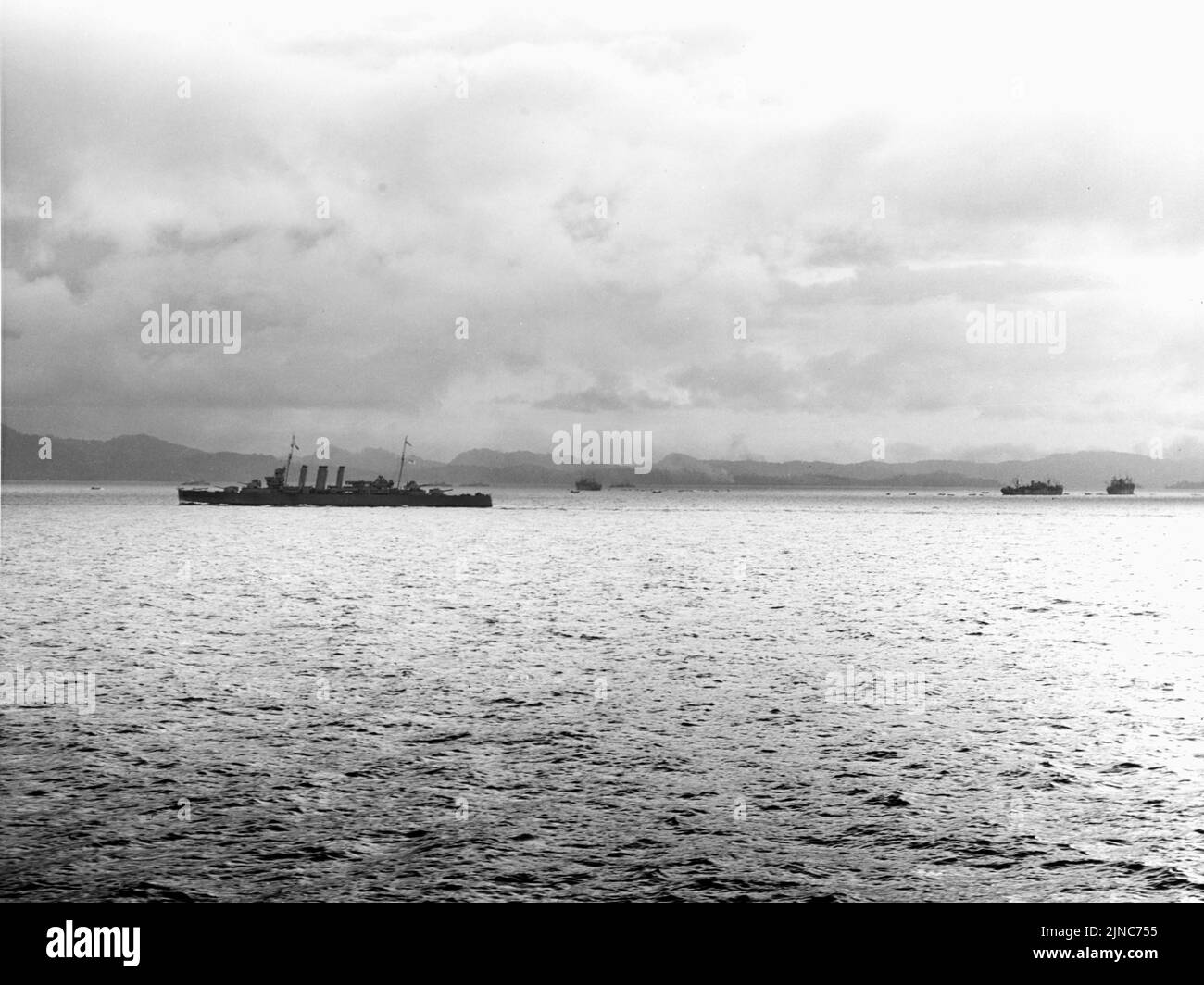 HMAS Canberra protects three Allied transport ships  unloading troops and supplies at Tulagi Island during the Guadalcanal campaign of WW2 Stock Photo
