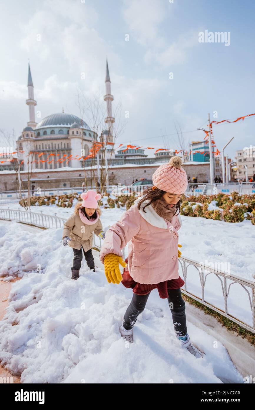 two little girl playing with snow in city square Stock Photo Alamy