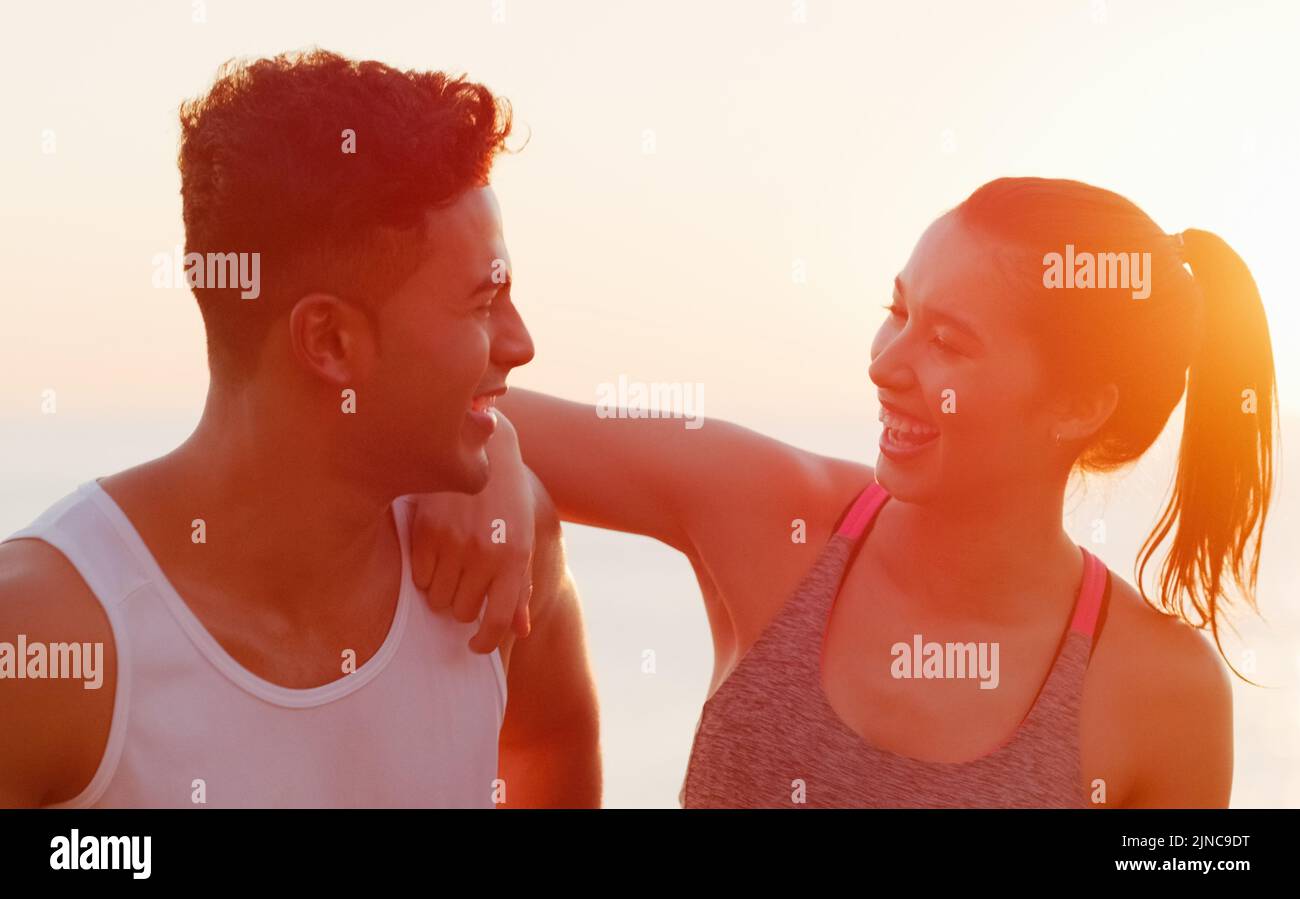 You always have a way to make me laugh. a happy young couple laughing together while working out outdoors. Stock Photo