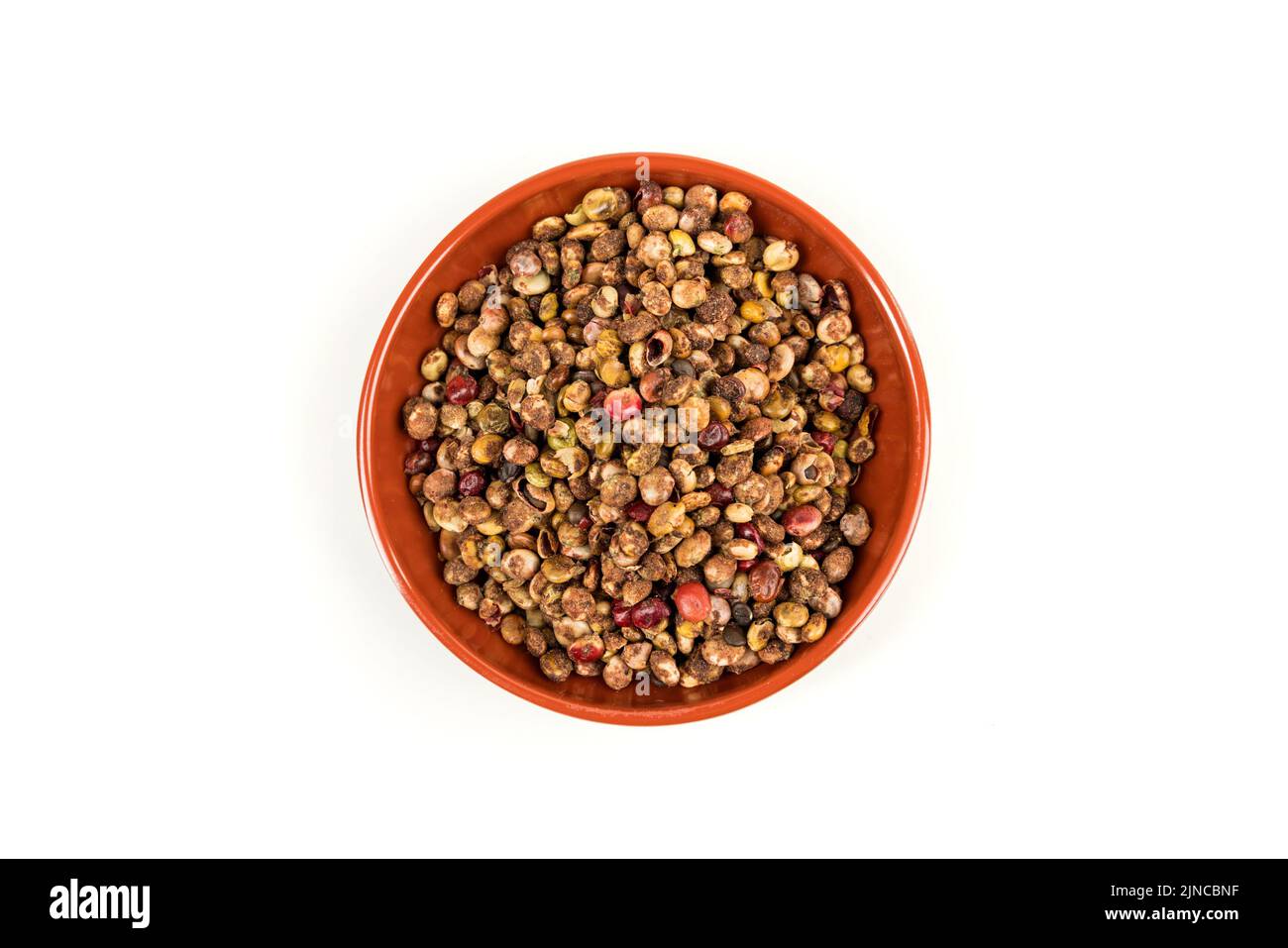 Whole dried sumac berries in a small red and black bowl over white top