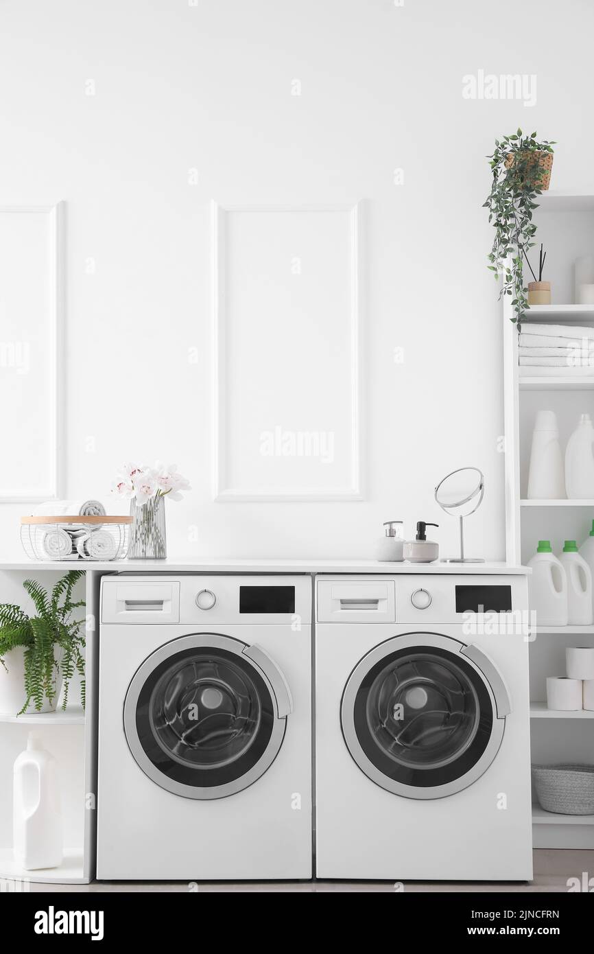 Interior of light laundry room with washing machines and shelving units Stock Photo Alamy