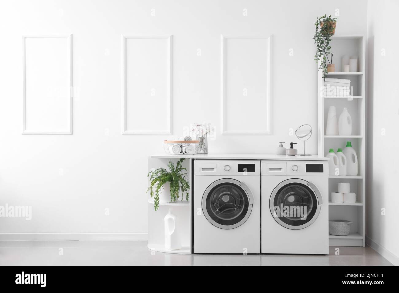 Interior of light laundry room with washing machines and shelving units Stock Photo Alamy