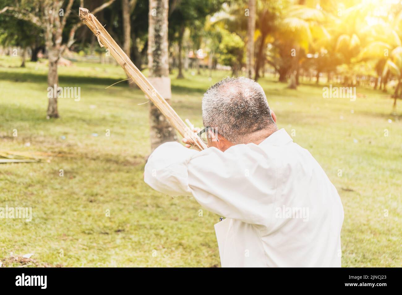 Old man from Nicaragua, Central America, aiming at a target with a bow and arrow Stock Photo