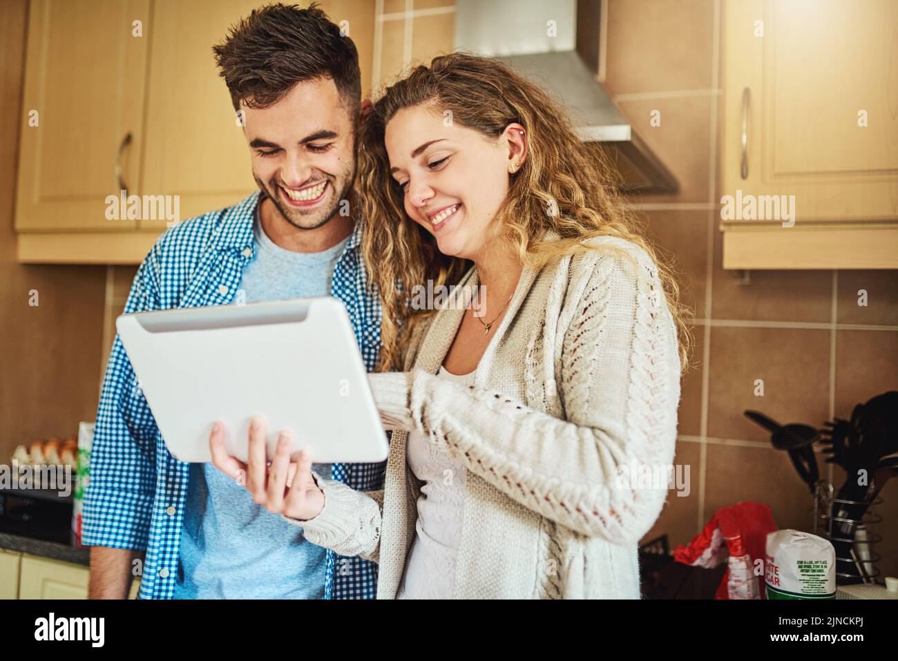 Keeping in touch with our friends. a loving couple using a digital tablet together at home. Stock Photo