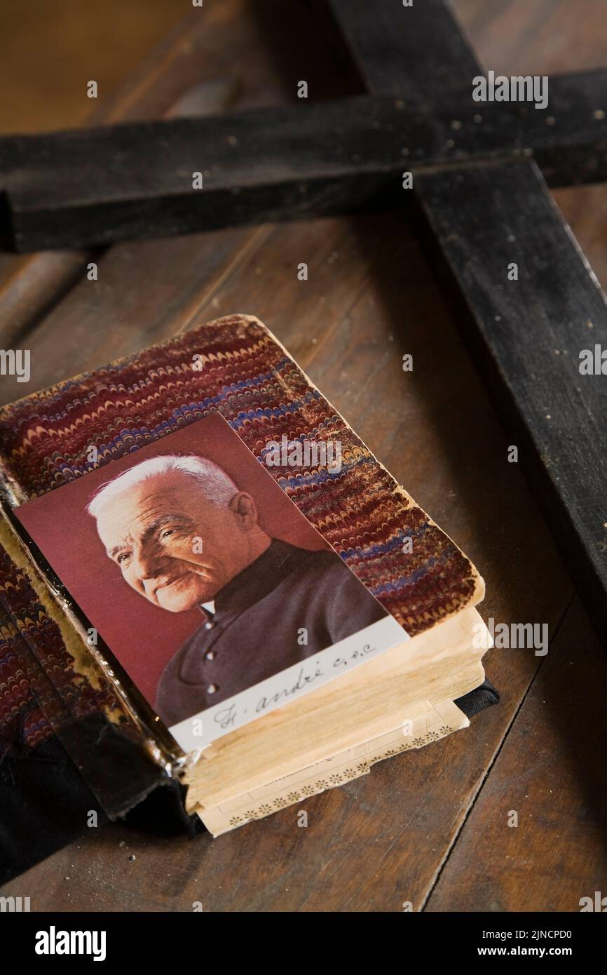 Photo of SaintAndre Bessette and black wooden cross on top of an old