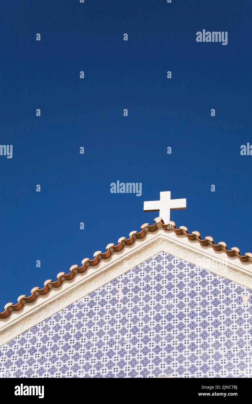 White cross on top of a church roof in Nazare Beach, Portugal. Stock Photo