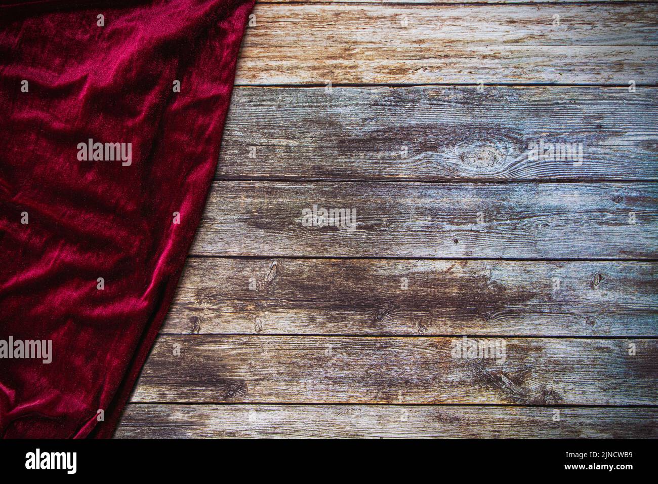 Red fabric velvet table cloth on empty wooden table background with copy space. Stock Photo