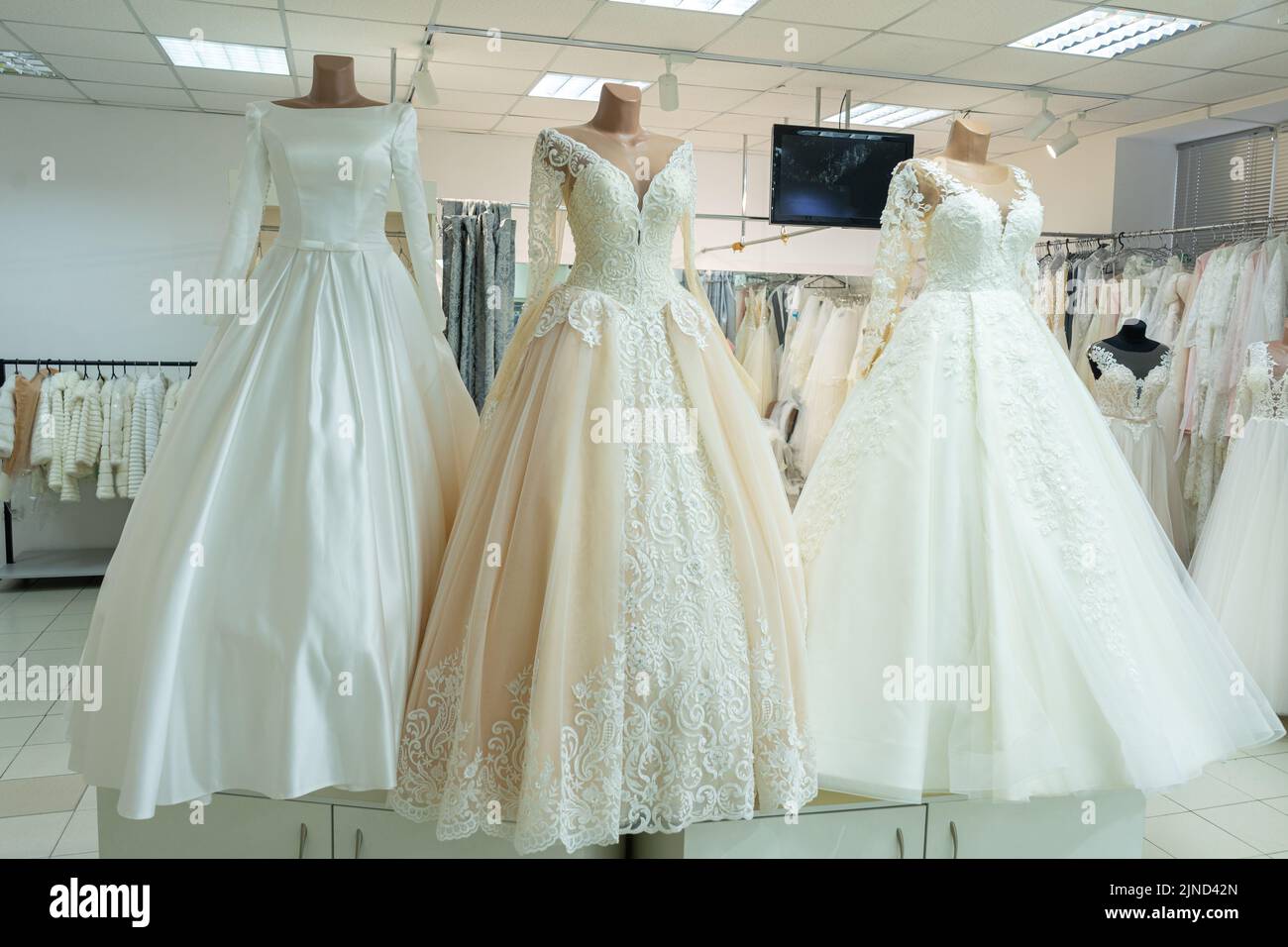 Three chic wedding dresses on mannequins. Three different models of beautiful wedding dresses. Stock Photo