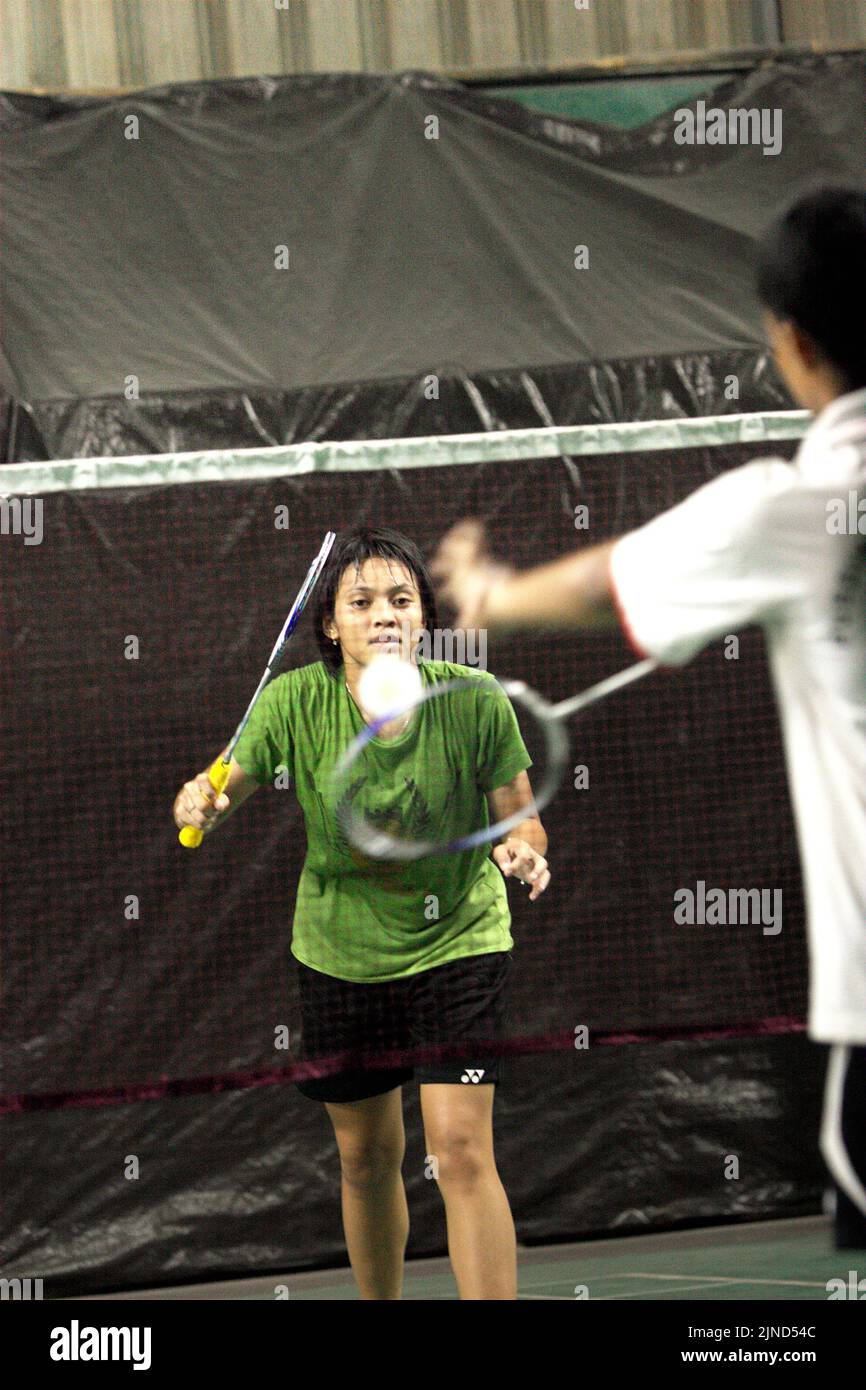 Young badminton athletes playing in a match game for women's doubles during a training session at Jaya Raya badminton club in Jakarta, Indonesia. Stock Photo