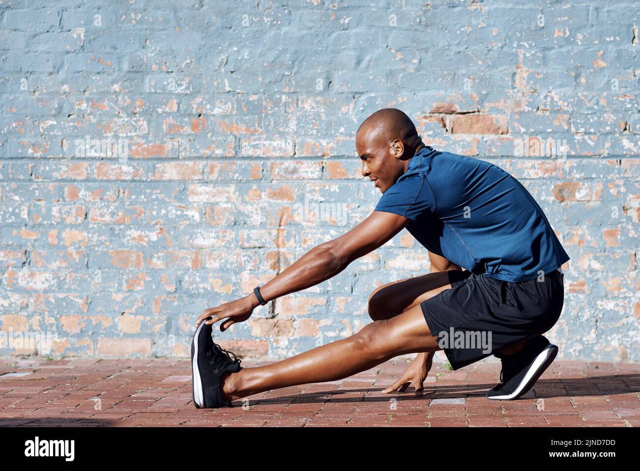 Now is the perfect time to start. a sporty young man exercising outside ...