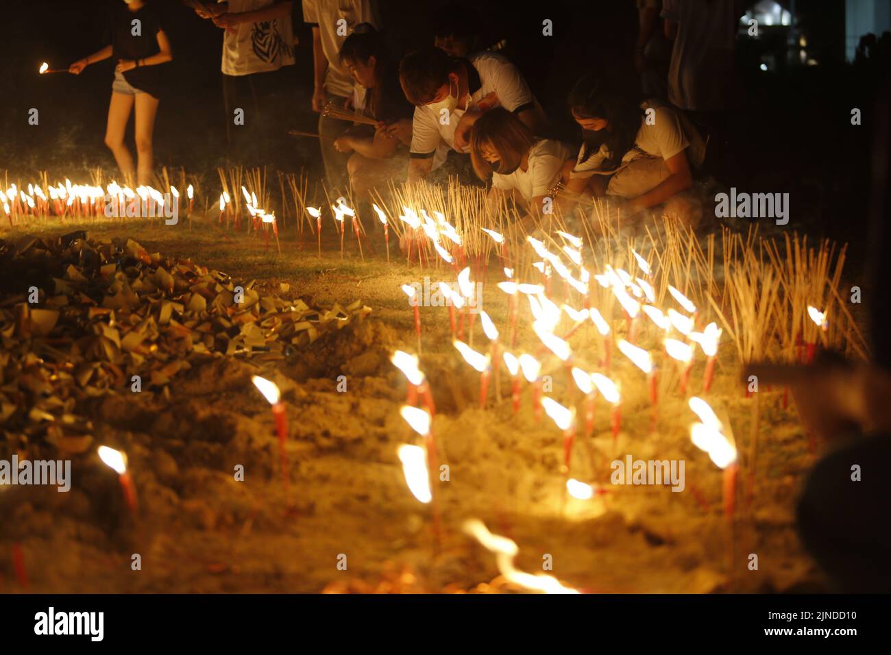 Devotees burn candles and joss sticks during the Hungry Ghost Festival