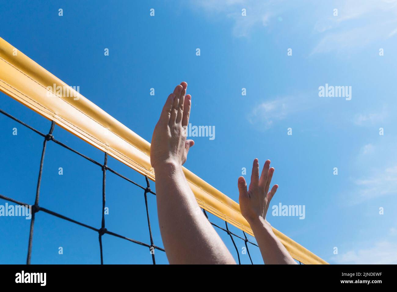 Volleyball spike hand block over the net. close-up reach for ball Stock Photo