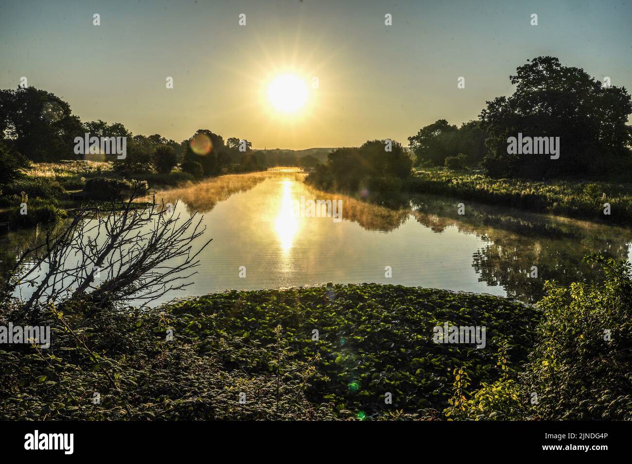 The sun rises over Berwick Pond in Rainham, Essex. Picture date: Thursday August 11, 2022. Stock Photo