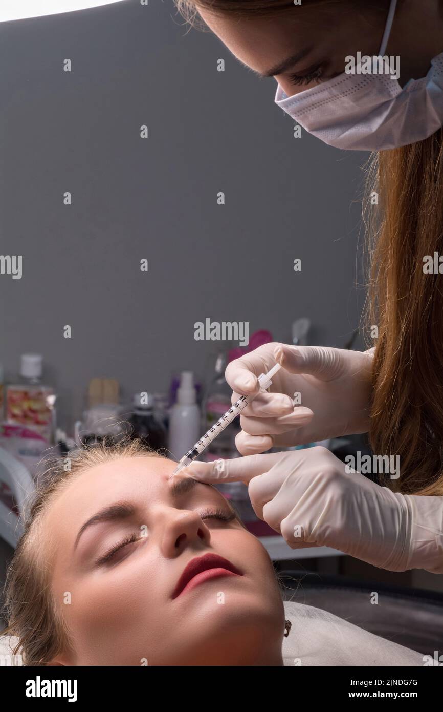 Woman getting cosmetic injection of botulinum on face Stock Photo