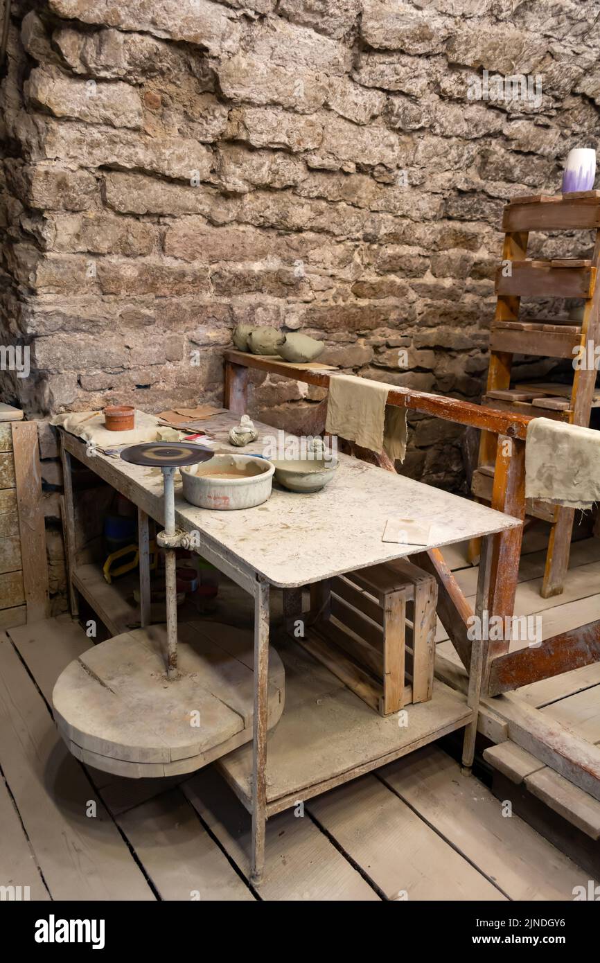 Potter's workshop. A working table with clay and a potter's wheel. Stock Photo