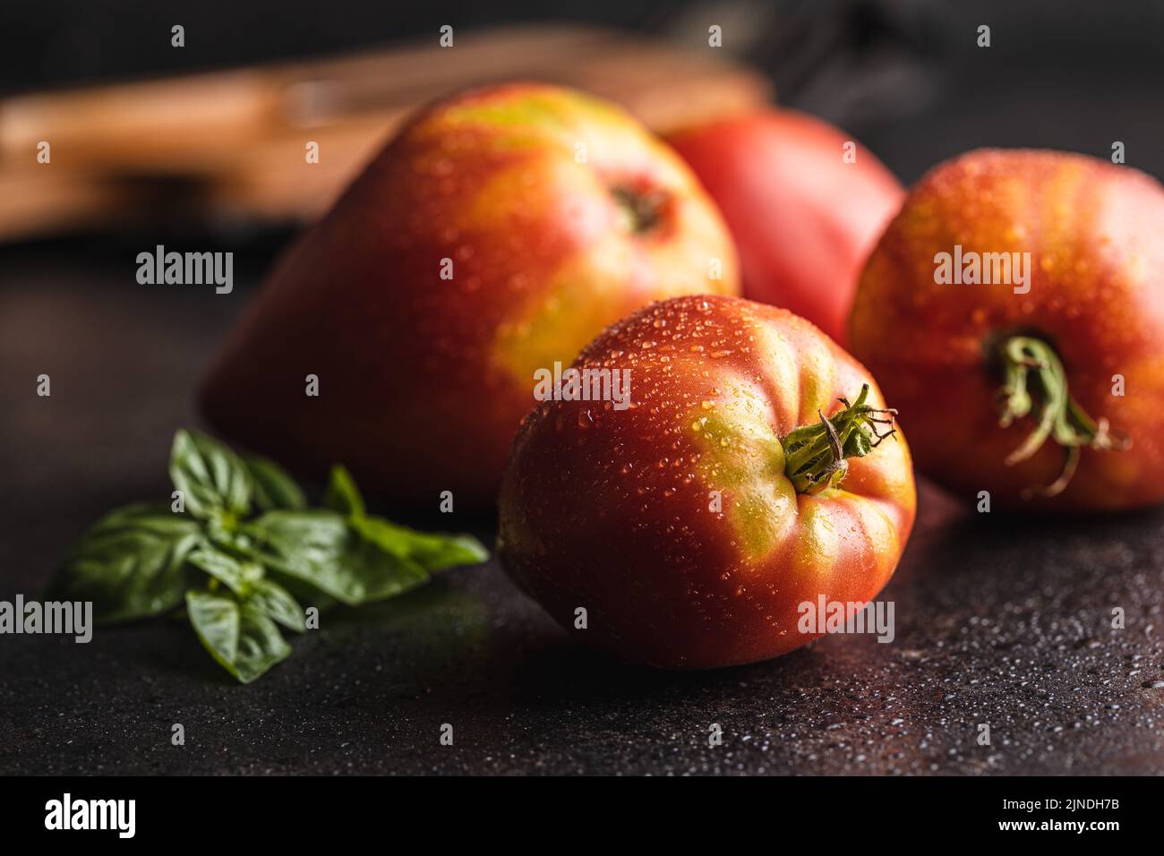 Bull heart tomatoes on a black table. Stock Photo